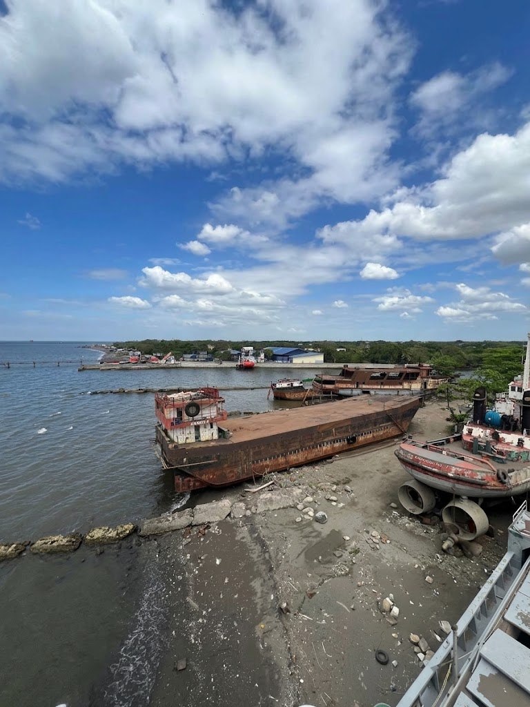 Vessels hauled out along the Vistamarine shoreline, with a rusted barge on the beach