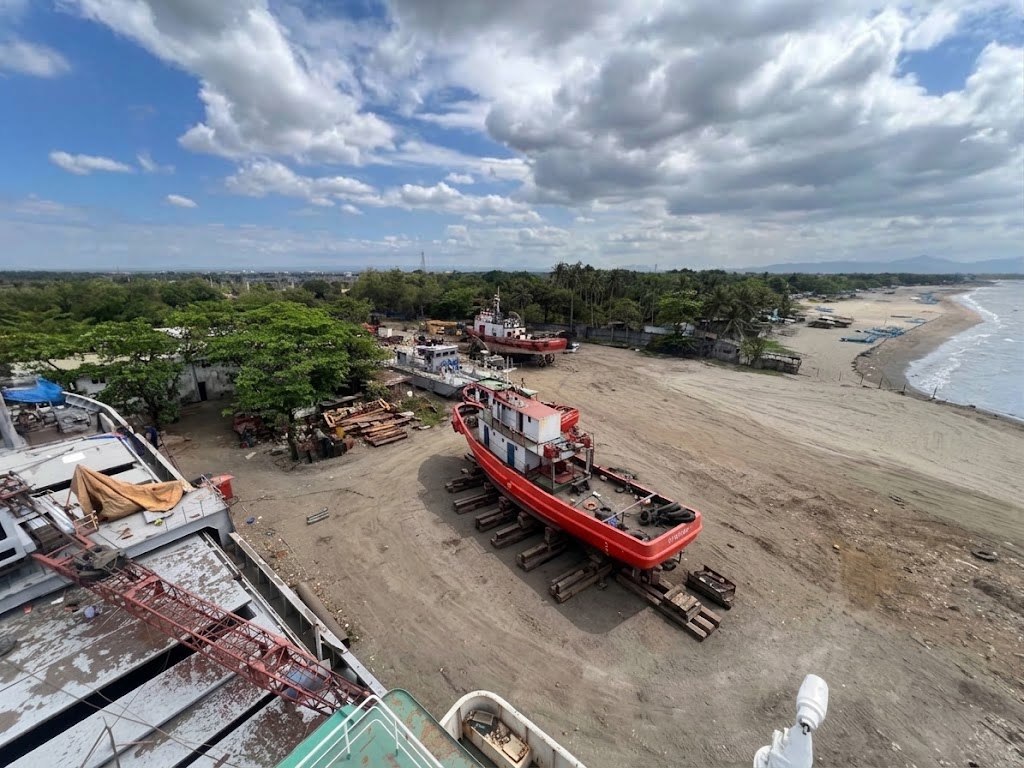 Vistamarine yard at Naic, Cavite: a red tugboat on the slipway beside the beach